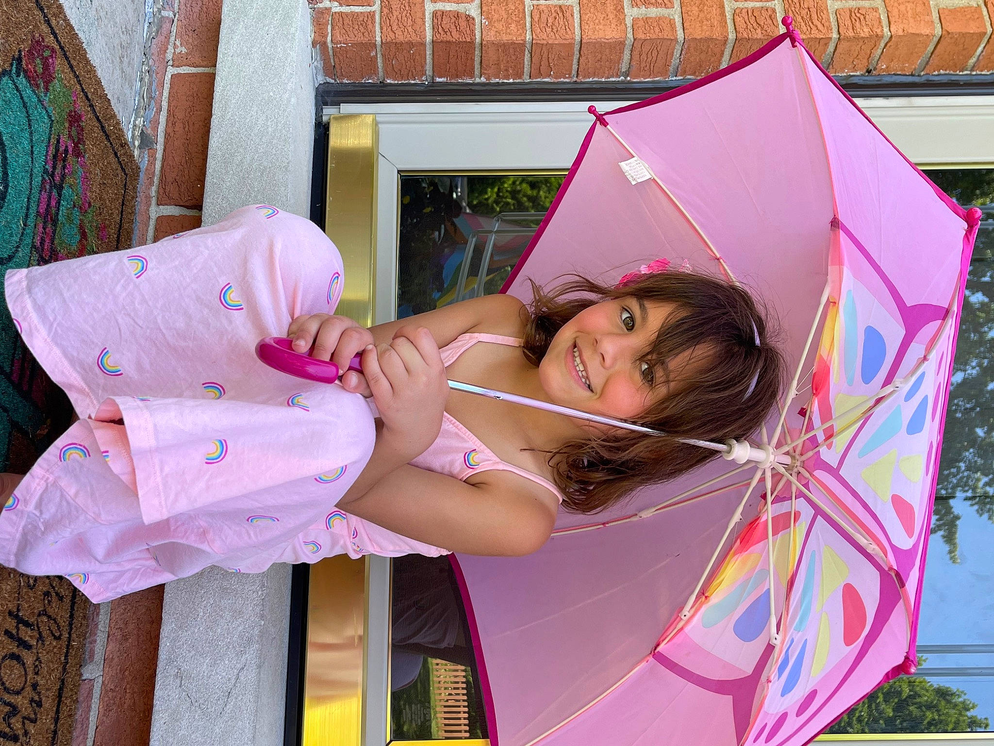 Aria is registered to the contest to win money with this photo: child, costume, dress, event, fashion_accessory, fun, happy, japanese_idol, joy, leisure, magenta, person, pink, skin, thigh, umbrella, window