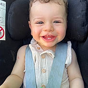 Izaia participe au concours pour gagner de l'argent avec cette photo : toddler, child, smiling, curly_hair, car_seat, seatbelt, toy, blue, green, white_clothing, buttons, face, happy, baby, infant, cute, portrait, indoor, closeup, person