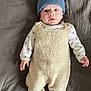 baby, infant, blue_hat, fuzzy_outfit, blanket, lying_down, wide_eyes, curious, cozy, cute, child, portrait, soft_texture, indoor, warm_clothing, hands, feet, sleepwear, person, newborn