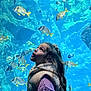 Elena participe au concours pour gagner de l'argent avec cette photo : child, girl, aquarium, fish, underwater, rocks, blue, curious, long_hair, vest, purple_sweater, scrunchie, marine_life, water, nature, portrait, indoor, young, person, excitement