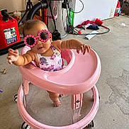 Fucshia joined the competition — help win amazing prizes! baby, pink_walker, sunglasses, flower_shaped, garage, floor, toy, baby_clothing, baby_walker, child, person, playful, reaching, headwear, footwear, plastic, container, vacuum_cleaner, red_gas_can, concrete_floor