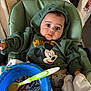 avengers, baby, bowl, child, curious, cute, feeding, food, green_clothing, high_chair, hoodie, indoor, infant, kitchen, messy_face, mickey_mouse, person, seat_belt, spoon, toy