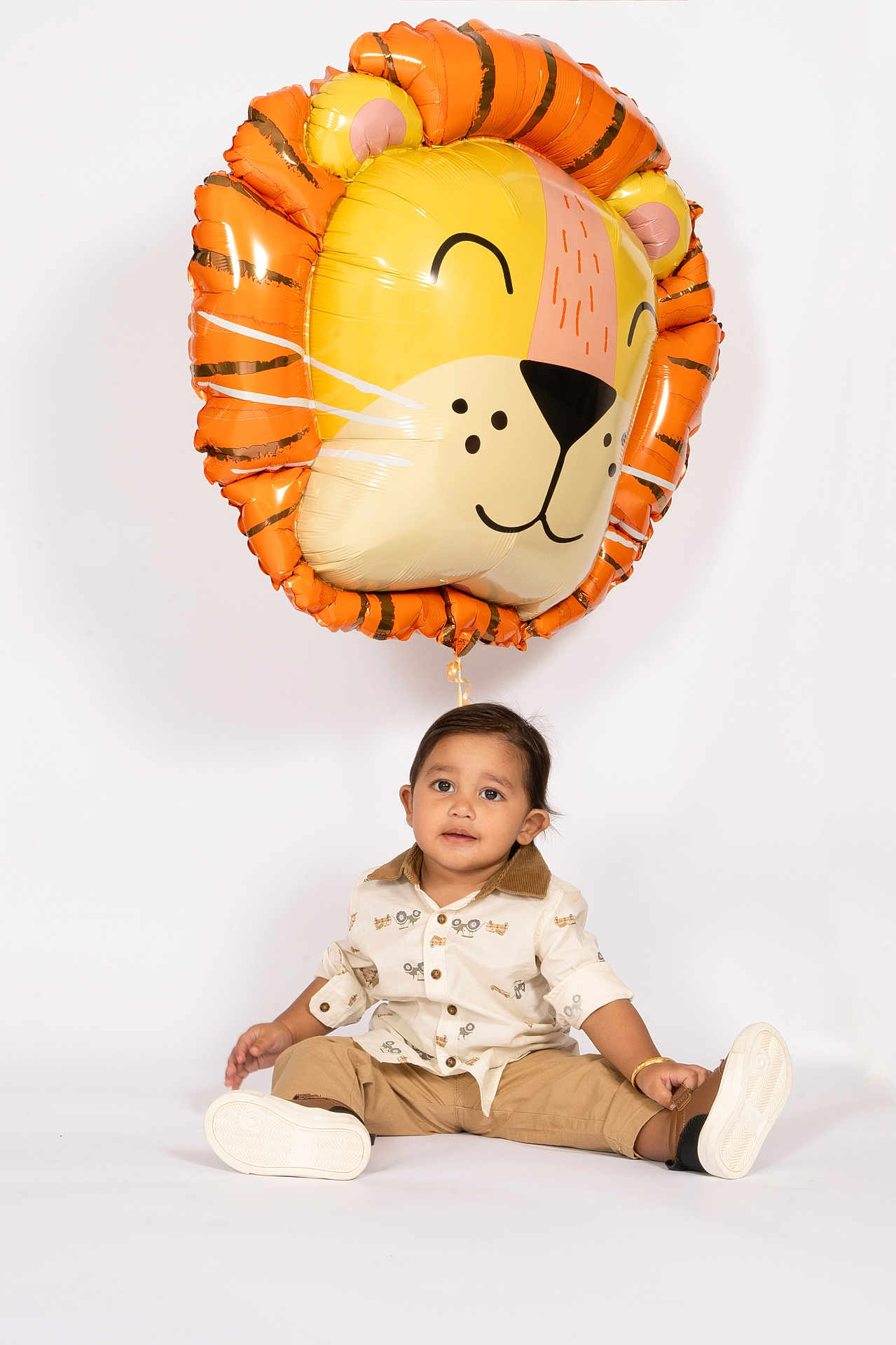 Jodhveer joined the competition — help win amazing prizes! toddler, child, balloon, lion_balloon, studio, white_background, casual_clothing, sitting, footwear, smiling, cute, playful, indoor, portrait, person, young_child, fashion, toy, celebration, happy