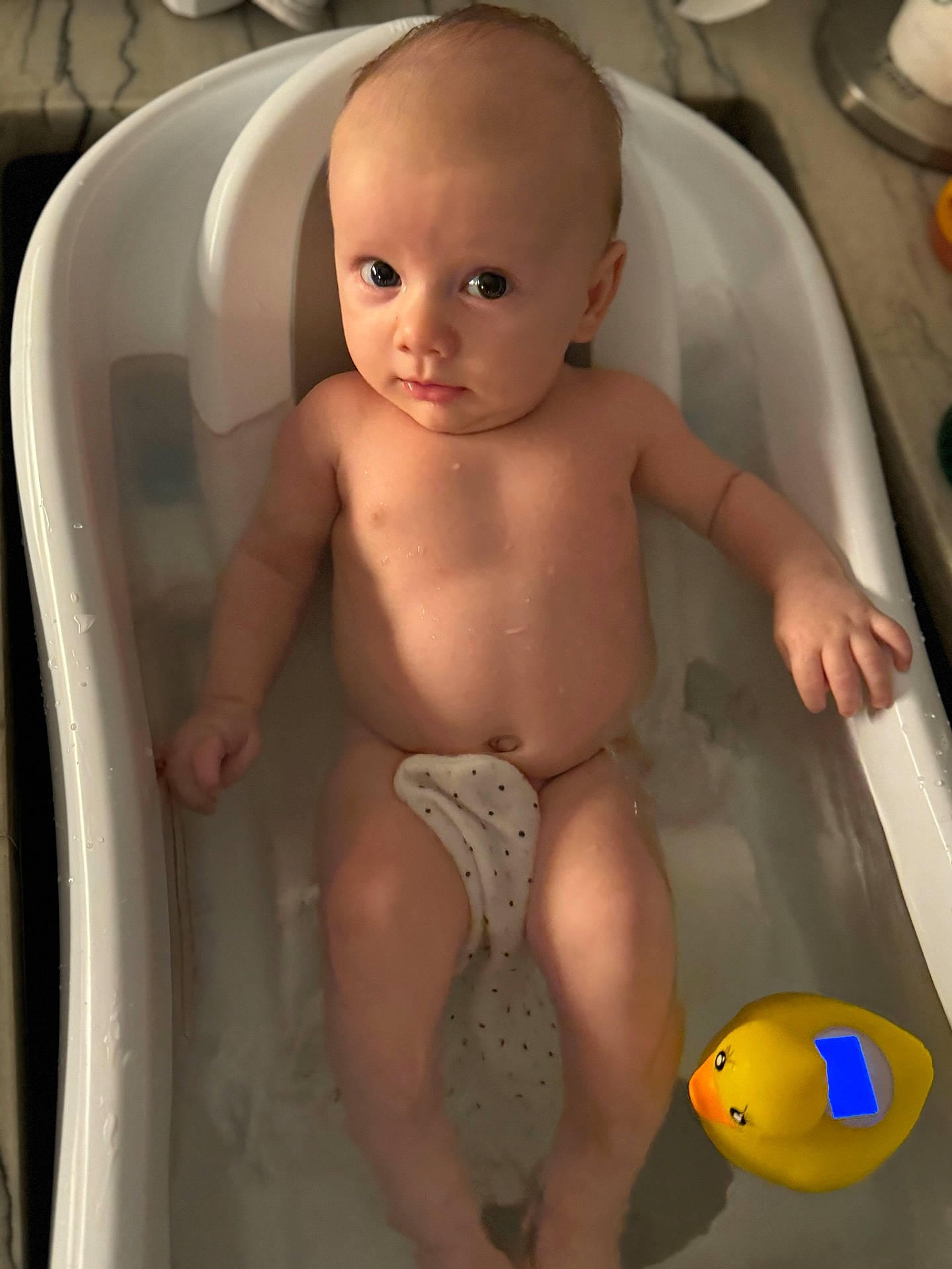 Luke is registered to the contest to win money with this photo: baby, bathing, bathtub, face, head, newborn, person, photography, portrait, toy, tub