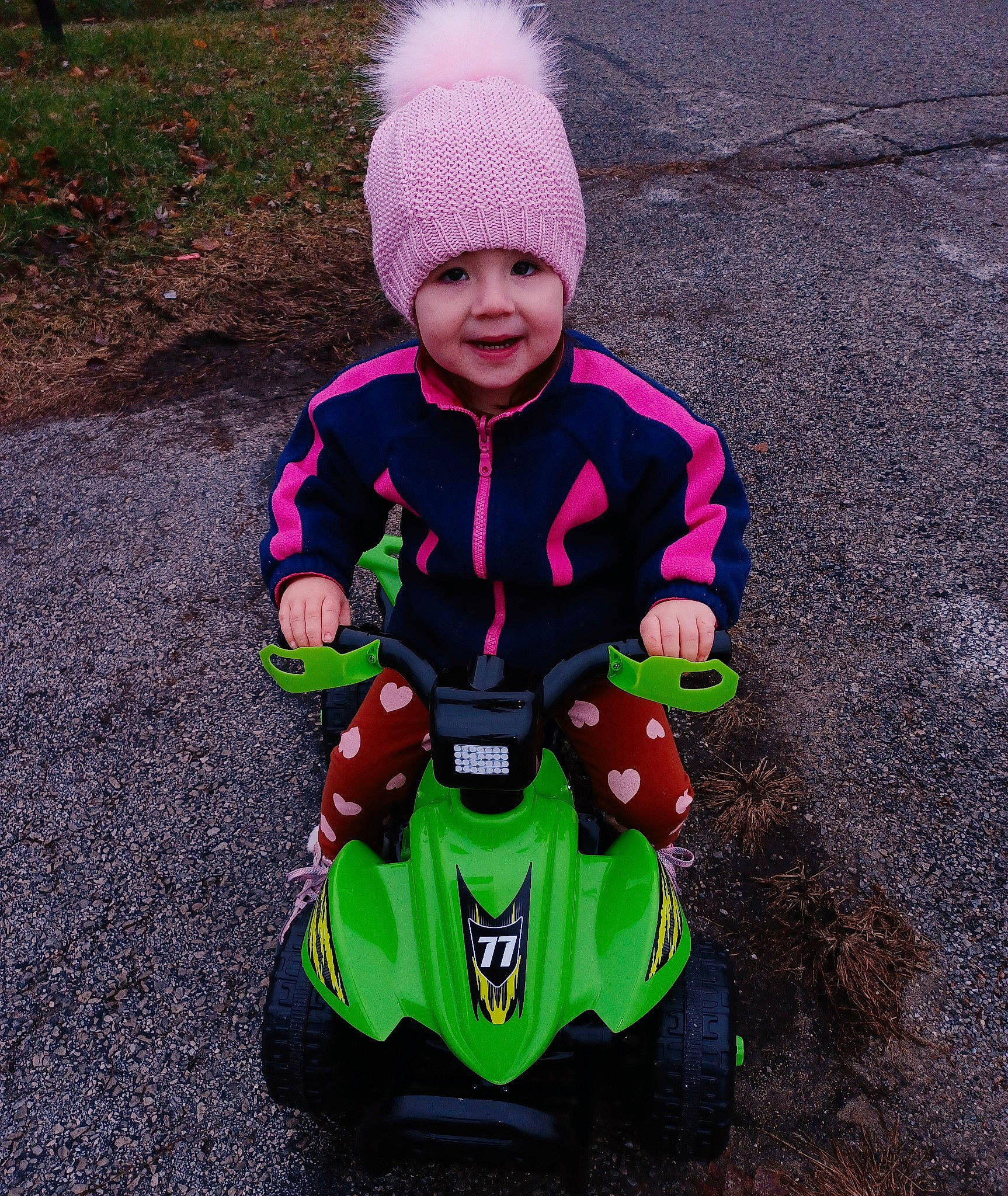 Brayleigh joined the competition — help win amazing prizes! asphalt, automotive_lighting, automotive_tire, baby, baby_carriage, baby_toddler_clothing, cap, grass, headgear, headwear, helmet, jacket, outerwear, person, plant, recreation, riding_toy, rolling, tire, toddler