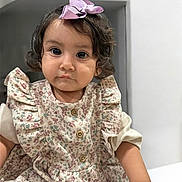 Keyla is registered to the contest to win money with this photo: toddler, child, girl, portrait, indoor, curly_hair, bow, dress, floral_pattern, cute, baby, face, eyes, smile, person, sitting, clothing, skin, young, fashion