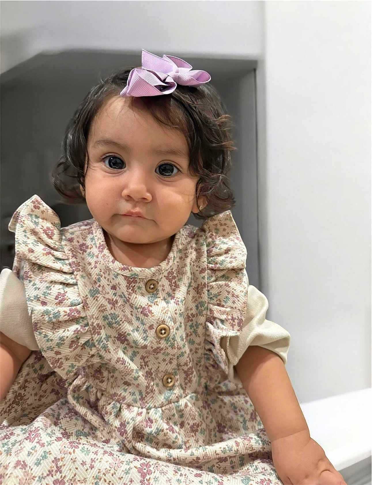 Keyla is registered to the contest to win money with this photo: toddler, child, girl, portrait, indoor, curly_hair, bow, dress, floral_pattern, cute, baby, face, eyes, smile, person, sitting, clothing, skin, young, fashion