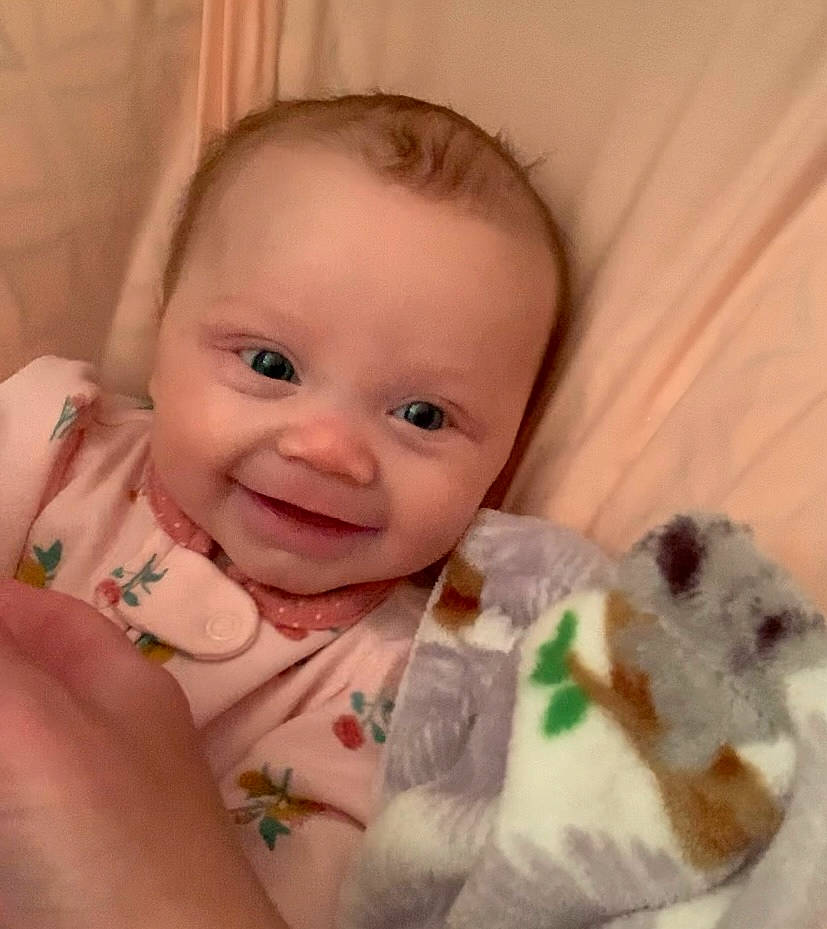 Emmy is registered to the contest to win money with this photo: baby, baby_toddler_clothing, cheek, chin, dress, eye, eyebrow, face, finger, gesture, happy, head, human_body, iris, joy, lip, nose, person, skin, sleeve