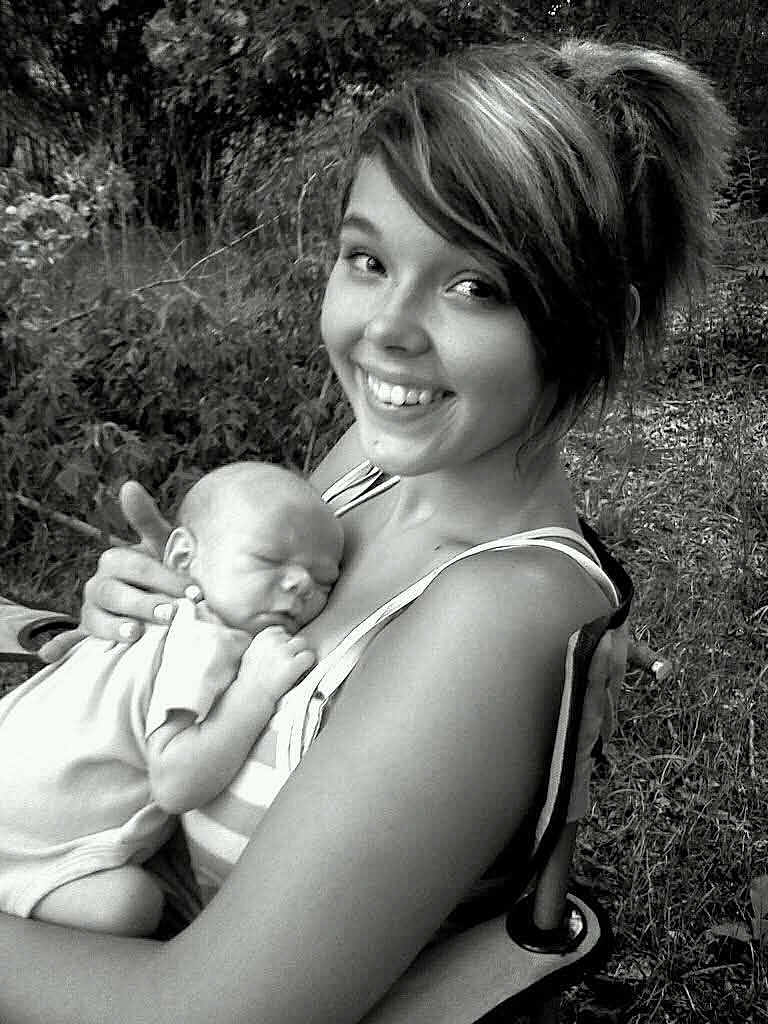 Hunter joined the competition — help win amazing prizes! baby, woman, smile, outdoor, nature, black_and_white, portrait, happy, infant, holding, grass, person, young_adult, face, head, sitting, tender, affection, resting, clothing