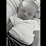 Ryker is registered to the contest to win money with this photo: baby, sleeping, infant, blanket, striped_clothing, cozy, peaceful, cute, small_hand, soft_texture, monochrome, newborn, portrait, resting, toddler, child, laying_down, indoors, clothing, head