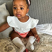 Tahiri is registered to the contest to win money with this photo: bodypart, child, clothing, couch, cushion, diaper, face, female, finger, furniture, girl, hand, head, homedecor, hosiery, person, photography, portrait, sitting, sock