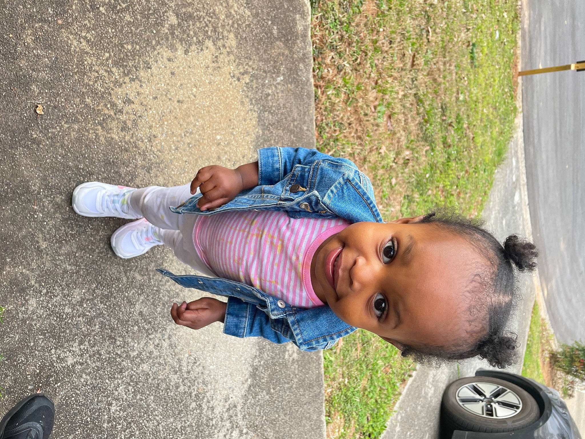 Alaysia is registered to the contest to win money with this photo: asphalt, automotive_tire, baby, child, electric_blue, fun, grass, human_leg, joy, leisure, person, plant, road_surface, shadow, sidewalk, sitting, soil, street, tire, toddler