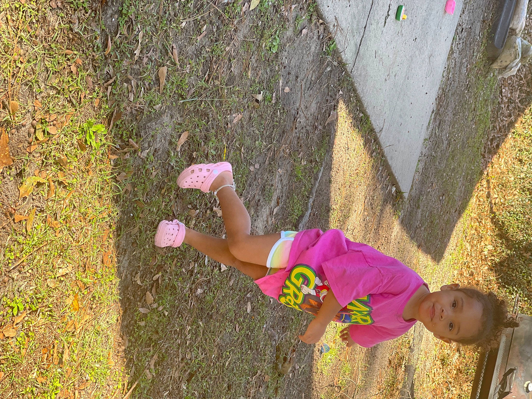 Kylie is registered to the contest to win money with this photo: child, concrete, fun, grass, grass_family, happy, hat, joy, leisure, magenta, people_in_nature, person, plant, play, recreation, shadow, soil, t_shirt, thigh, toddler