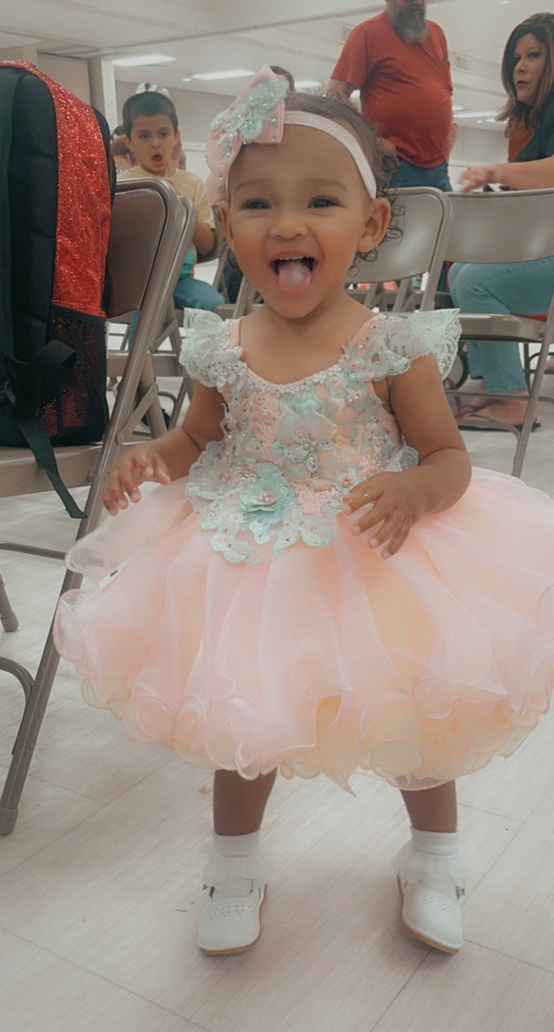 Kapri is registered to the contest to win money with this photo: baby, baby_toddler_clothing, chair, child, dress, embellishment, entertainment, event, face, fun, furniture, happy, headwear, person, photograph, pink, purple, ruffle, skin, smile