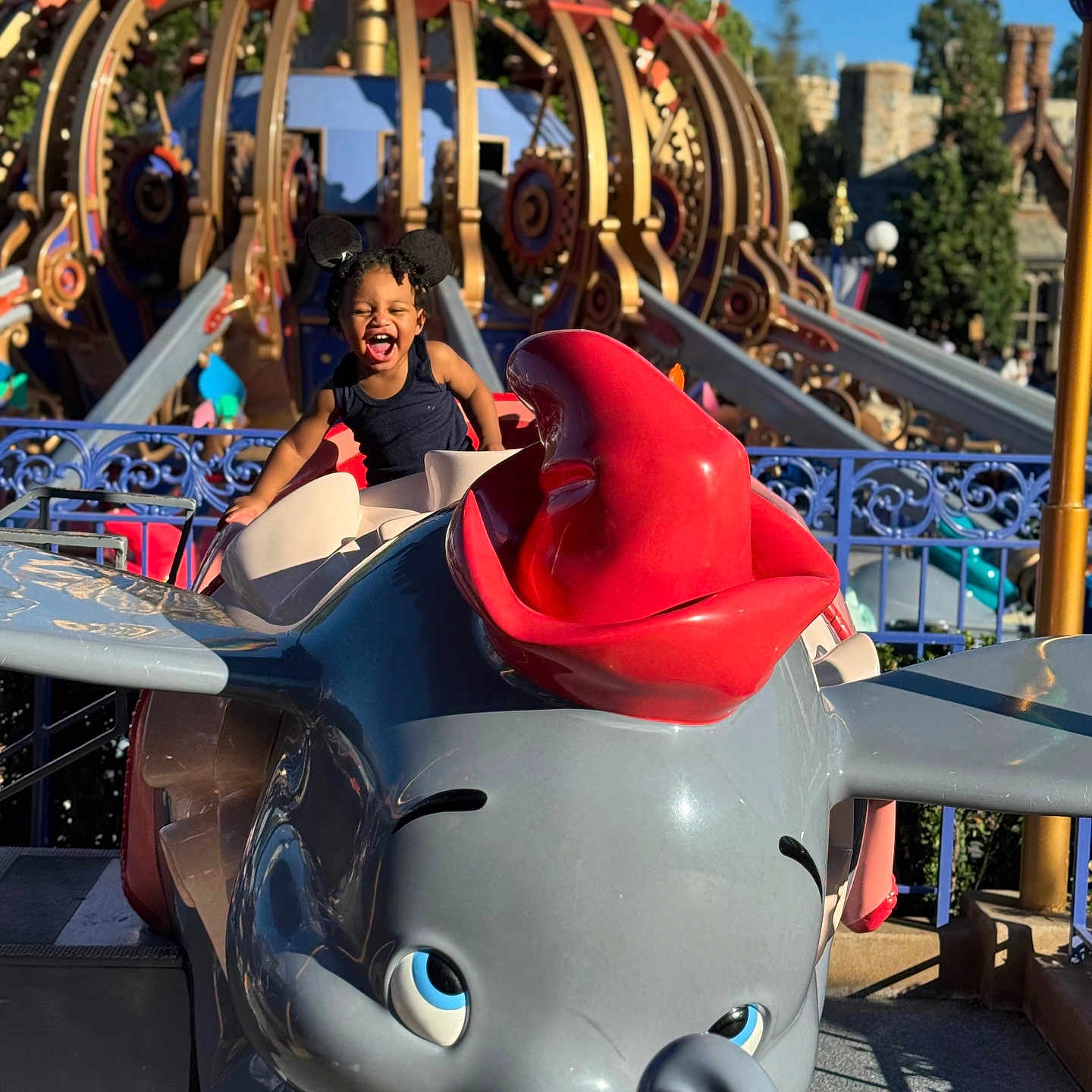 Kahlil is registered to the contest to win money with this photo: amusement_park, blue_sky, child, colorful, dumbo, elephant, entertainment, fun, happy, joy, mouse_ears, outdoor, playful, ride, smiling, sunlight, theme_park, toy, vacation, young_child