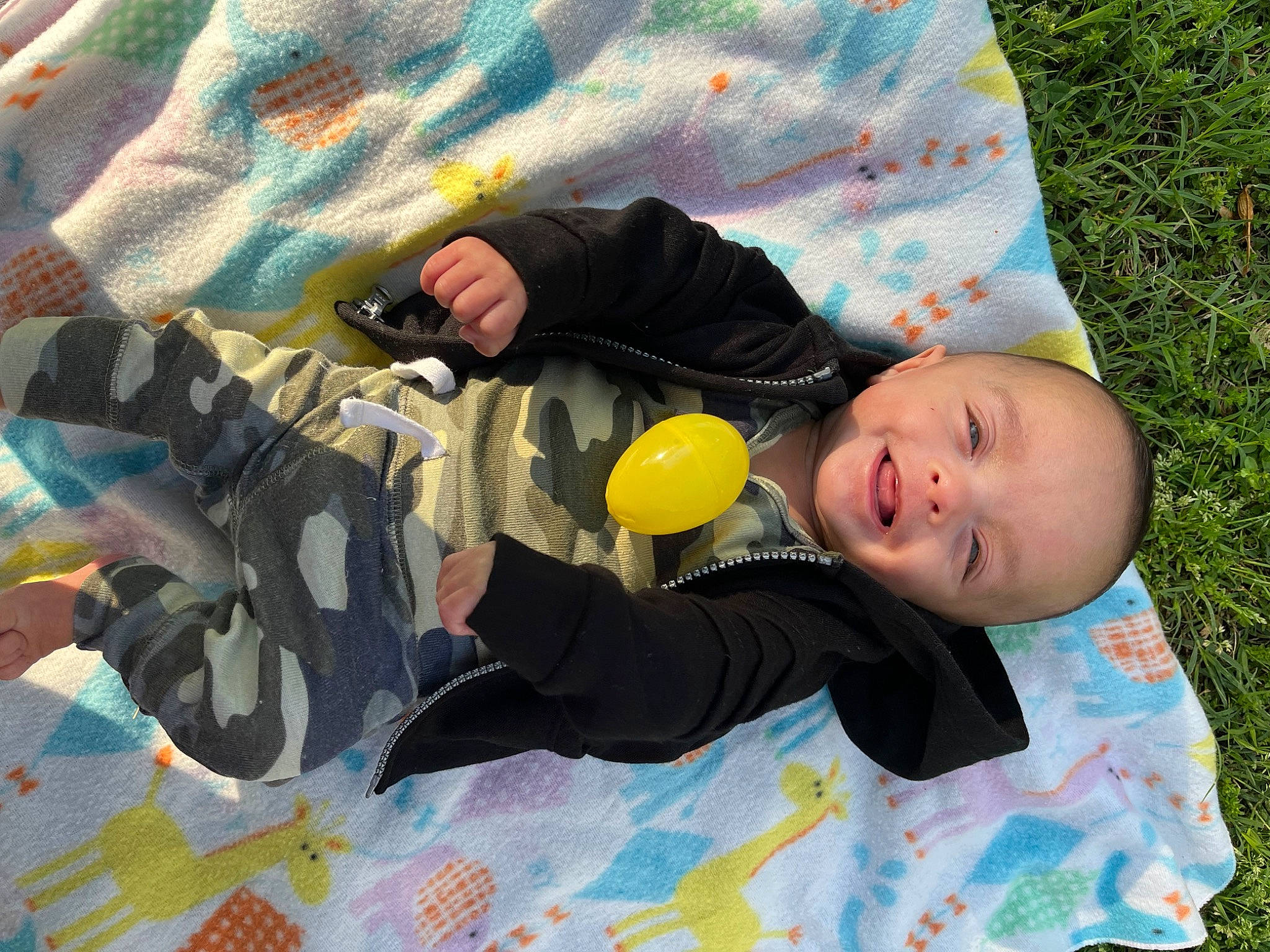 Jasiah joined the competition — help win amazing prizes! baby, baby_products, baby_toddler_clothing, child, comfort, fun, gesture, grass, happy, leisure, linens, military_camouflage, pattern, people_in_nature, person, sleeve, smile, textile, toddler, tree