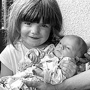Soan participe au concours pour gagner de l'argent avec cette photo : child, baby, newborn, holding, smile, portrait, black_and_white, person, face, hair, clothing, hand, infant, cute, family, toddler, expression, sitting, wall, texture