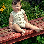 Julian is registered to the contest to win money with this photo: child, toddler, bench, outdoor, greenery, flowers, smile, grass, plants, sunlight, happy, sitting, nature, baby, summer, cute, shorts, shirt, portrait, garden