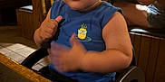 Julian joined the competition — help win amazing prizes! toddler, child, blue_tank_top, pineapple_logo, high_chair, wooden_table, restaurant, indoor, dining, person, face, arm, furniture, seat, food, casual_clothing, table, background_people, light, tile_floor