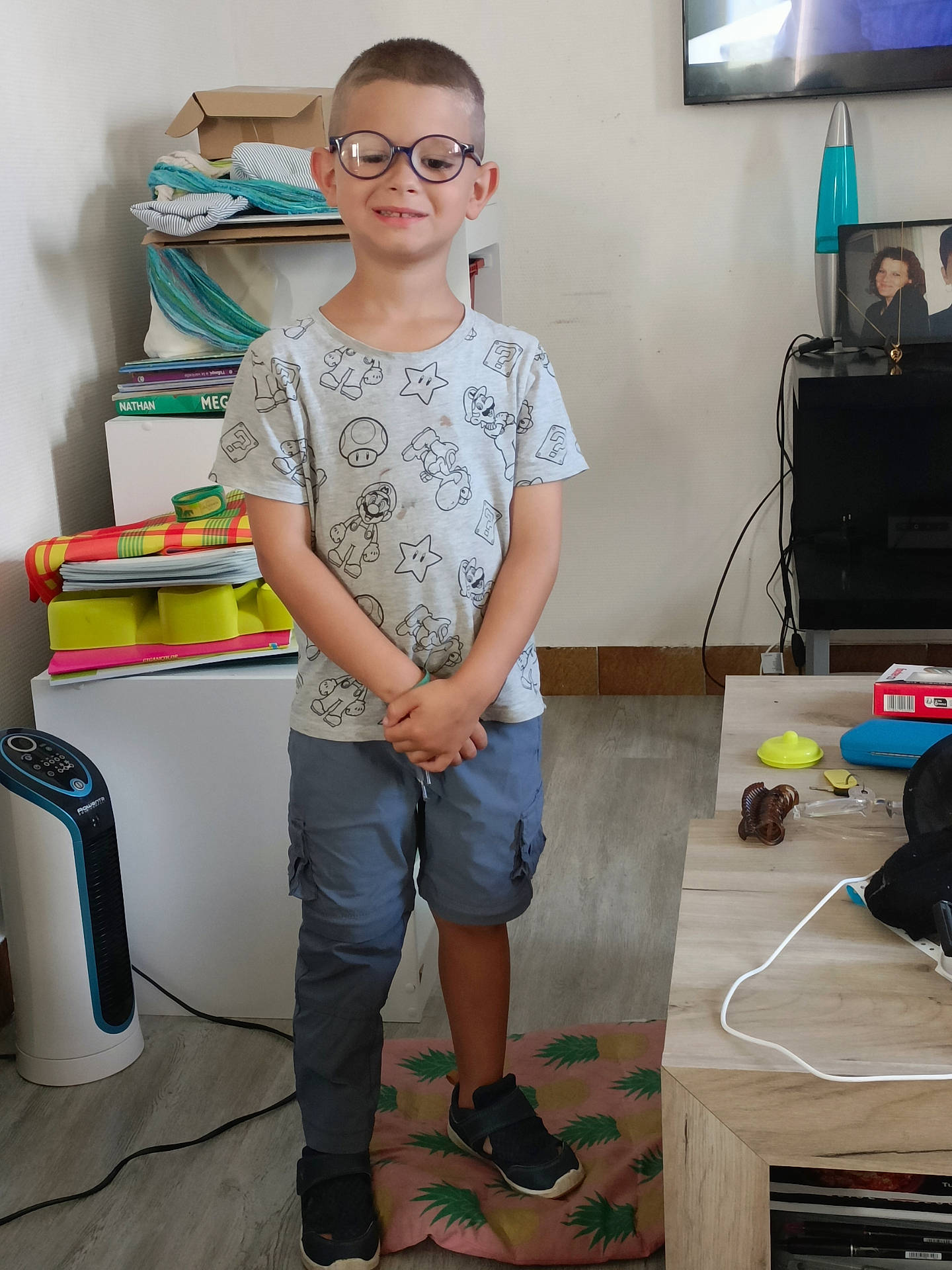 Luis participe au concours pour gagner de l'argent avec cette photo : accessories, boy, child, clothing, desk, face, footwear, furniture, glasses, head, jeans, male, pants, person, photography, portrait, shoe, standing, t_shirt, table