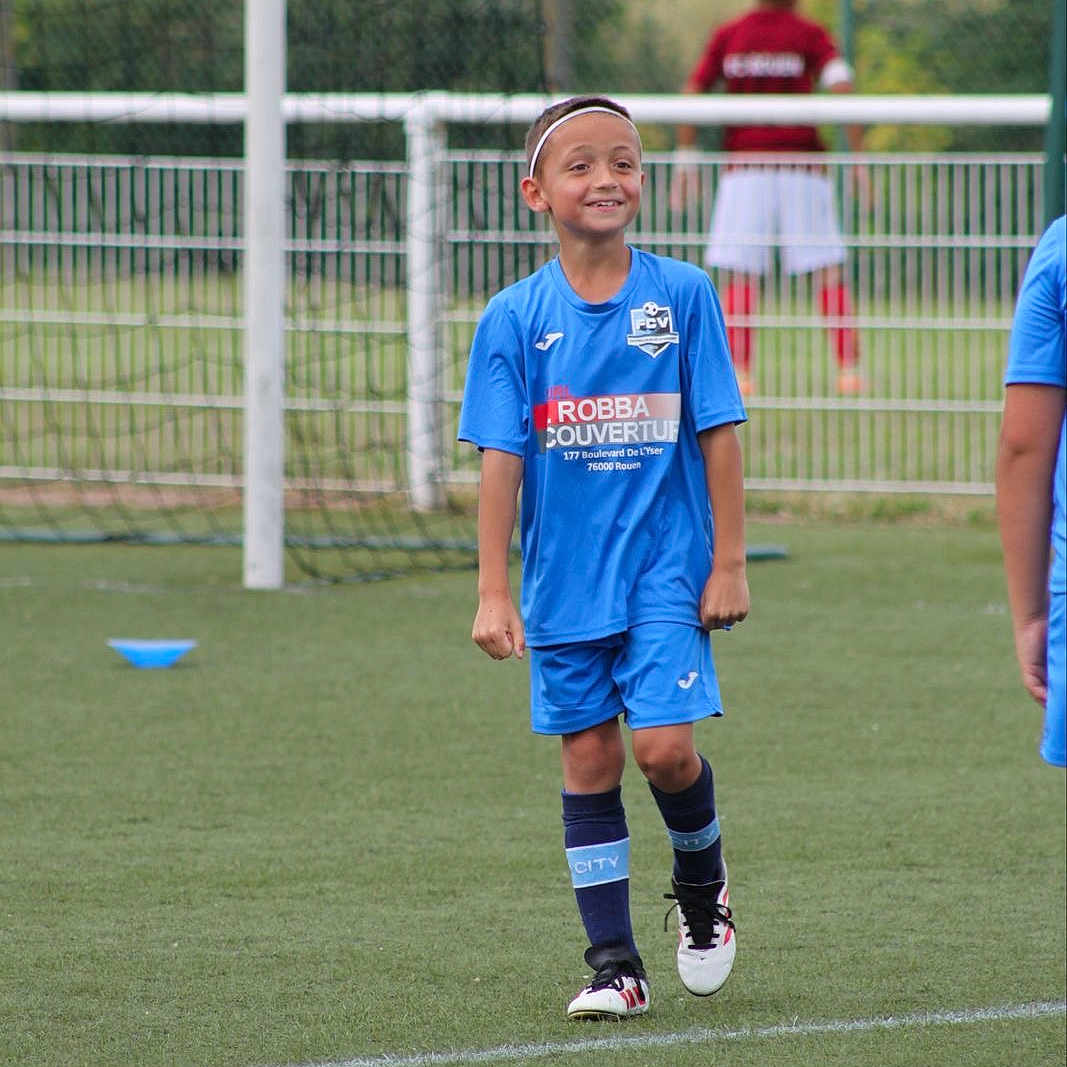 Louis a rejoint le concours — aidez-le/la à gagner de superbes lots ! athlete, blue_uniform, boy, child, cleats, field, goal, grass, headband, net, outdoor, playing, recreation, shorts, smiling, soccer, socks, sports, team, youth