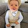 baby, child, smiling, hat, vest, bow_tie, white_clothing, couch, indoor, portrait, happy, seated, person, cute, infant, fashion, closeup, face, eyelashes, buttoned_clothing