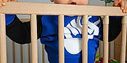 Nahël a rejoint le concours — aidez-le/la à gagner de superbes lots ! toddler, child, crib, wooden_bars, blue_eyes, blue_outfit, nike_logo, nursery, toys, basket, animal_decorations, curious, indoor, baby, person, clothing, playful, standing, furniture, home