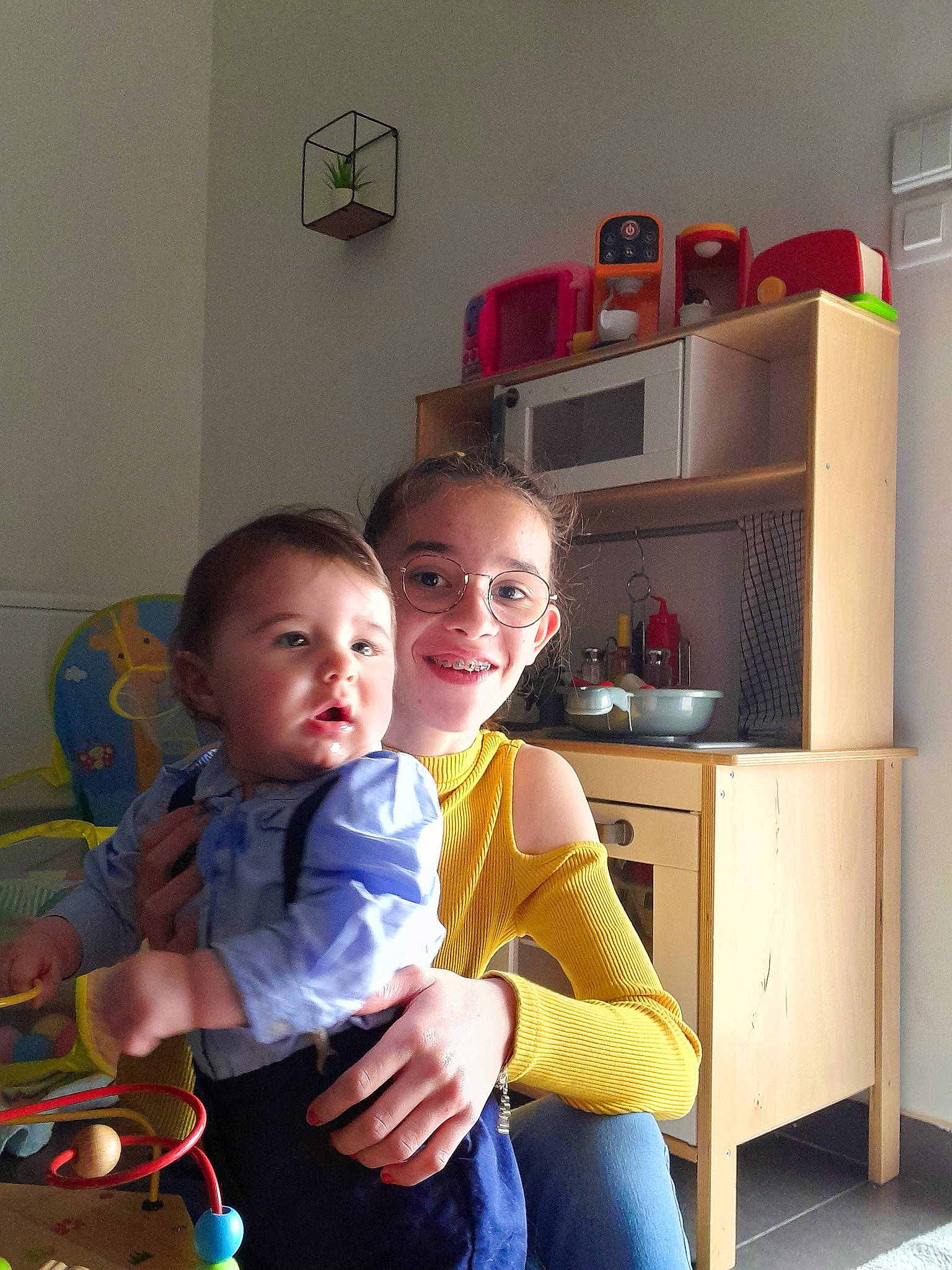 Gabriel participe au concours pour gagner de l'argent avec cette photo : baby, baby_toddler_clothing, cabinetry, chair, chest_of_drawers, child, comfort, cupboard, drawer, fun, happy, home_appliance, joy, living_room, person, refrigerator, room, shelf, shelving, sitting