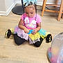 Eliana is registered to the contest to win money with this photo: ball, child, clothing, costume, face, female, football, furniture, girl, hair, head, pants, person, photography, portrait, sitting, soccer, soccerball, sport, wood