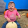 baby, child, pink_shirt, blue_background, pumpkin, white_pumpkin, hay, tombstone, smiling, outdoor, fall, autumn, jeans, socks, cute, festive, decoration, happy, portrait, sitting
