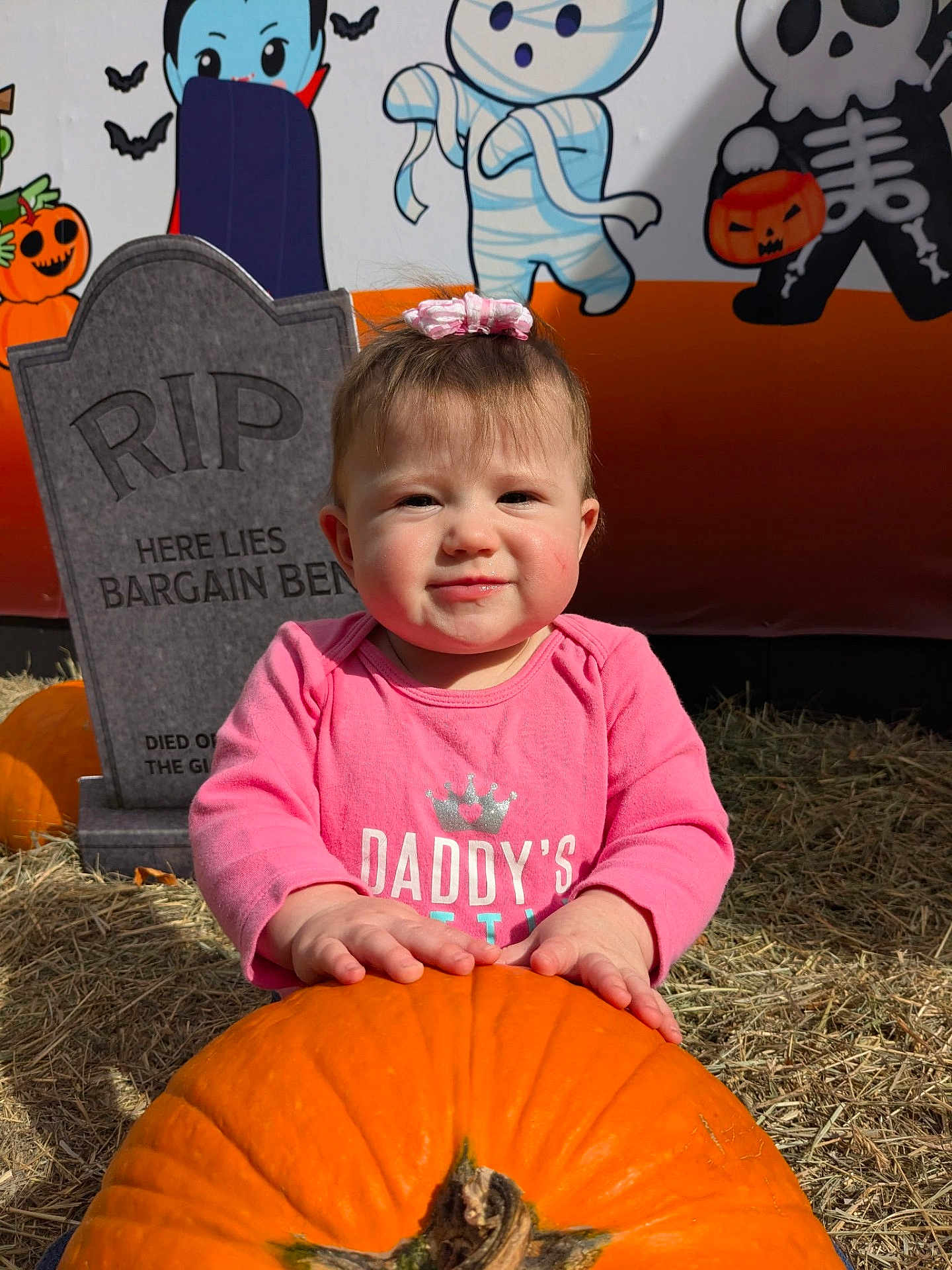 Ivory is registered to the contest to win money with this photo: baby, pumpkin, pink_clothing, child, halloween, tombstone, hay, outdoor, cartoon_characters, bat, ghost, smile, face, headwear, holiday, festive, orange, cute, autumn, portrait