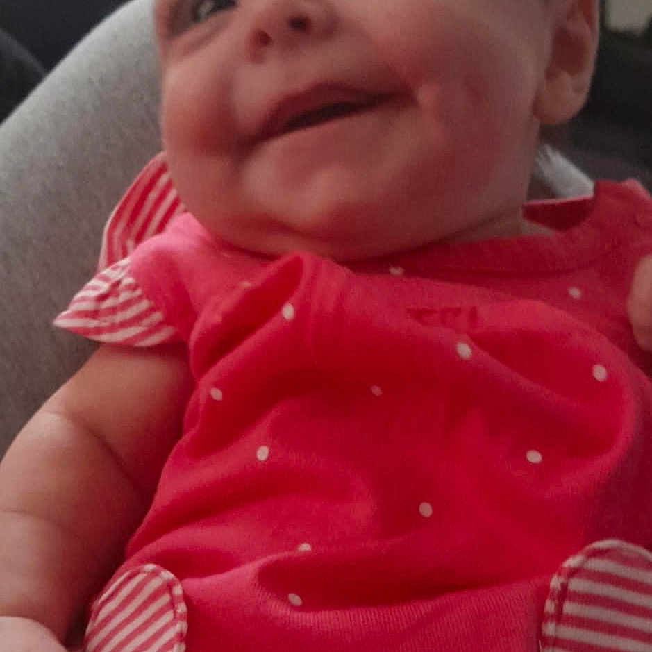 Scarlett is registered to the contest to win money with this photo: baby, babylaughing, bodypart, clothing, cushion, dress, face, happy, head, homedecor, laughing, mouth, newborn, person, photography, portrait, sitting, smile, t_shirt, teeth