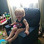 Stormie Blair joined the competition — help win amazing prizes! toddler, child, armchair, blue_chair, toys, stuffed_animals, baby_rocker, carpet, window, curtains, indoor, smiling, blonde_hair, baby_clothing, happy, small_furniture, playroom, child_sitting, soft_light, home