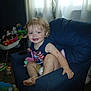 Stormie Blair joined the competition — help win amazing prizes! toddler, child, blue_armchair, smile, indoor, toy, curtain, diaper, blonde_hair, happy, barefoot, casual_clothing, living_room, plush_toy, pacifier, carpet, window, natural_light, person, playtime