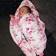 Serenity is registered to the contest to win money with this photo: apparel, baby, blanket, child, comfort, couch, cozy, face, floral, furniture, home, indoors, infant, peaceful, pink, relaxed, resting, sleeping, soft, wrapped