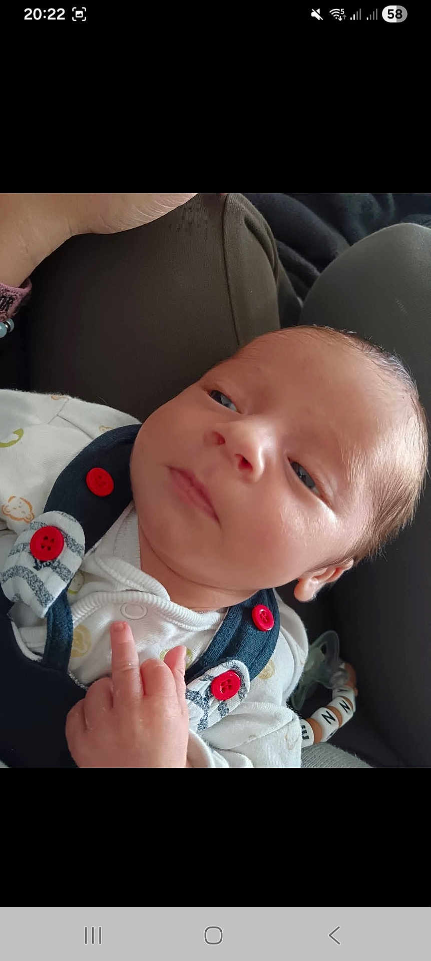 Lenny participe au concours pour gagner de l'argent avec cette photo : baby, infant, face, hand, clothing, red_buttons, pacifier, toy, lying_down, closeup, skin, eyes, expression, comfort, indoors, person, newborn, sleepwear, cute, soft