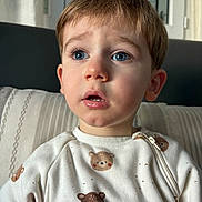 Marc Andria participe au concours pour gagner de l'argent avec cette photo : child, toddler, boy, face, blue_eyes, surprised_expression, short_hair, pajamas, bear_print, close_up, portrait, indoor, sofa, pillow, natural_light, window, skin, eyelashes, nose, mouth_open