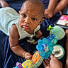 Saage joined the competition — help win amazing prizes! baby, infant, toy, hand, bracelet, blanket, colorful, curious, expression, indoor, person, child, playing, soft_toy, focus, portrait, skin, face, clothing, lying