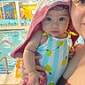 adult, baby, background, blue_chairs, child, colorful, cute, eyes, face, hand, holding, indoor, person, photography, pool, reflection, swimsuit, towel, water, yellow_wall