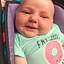 baby, cheeks, child, closeup, clothing, cute, donut_graphic, eyes, fabric, face, happy, indoors, infant, mint_green, patterned_background, portrait, seated, smiling, soft_lighting, tshirt