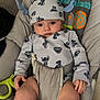 baby, infant, child, bouncer_seat, onesie, hat, patterned_clothing, stitch_character, wide_eyes, seat_belt, indoor, toy, colorful, fabric, portrait, cute, hands, legs, soft_furniture, carpet