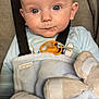baby, infant, car_seat, safety_strap, pacifier, pacifier_clip, blue_blanket, stuffed_elephant, onesie, big_eyes, chubby_cheeks, blonde_hair, close_up, portrait, grey_background, fabric, buckle, sitting, curious_expression, soft_lighting