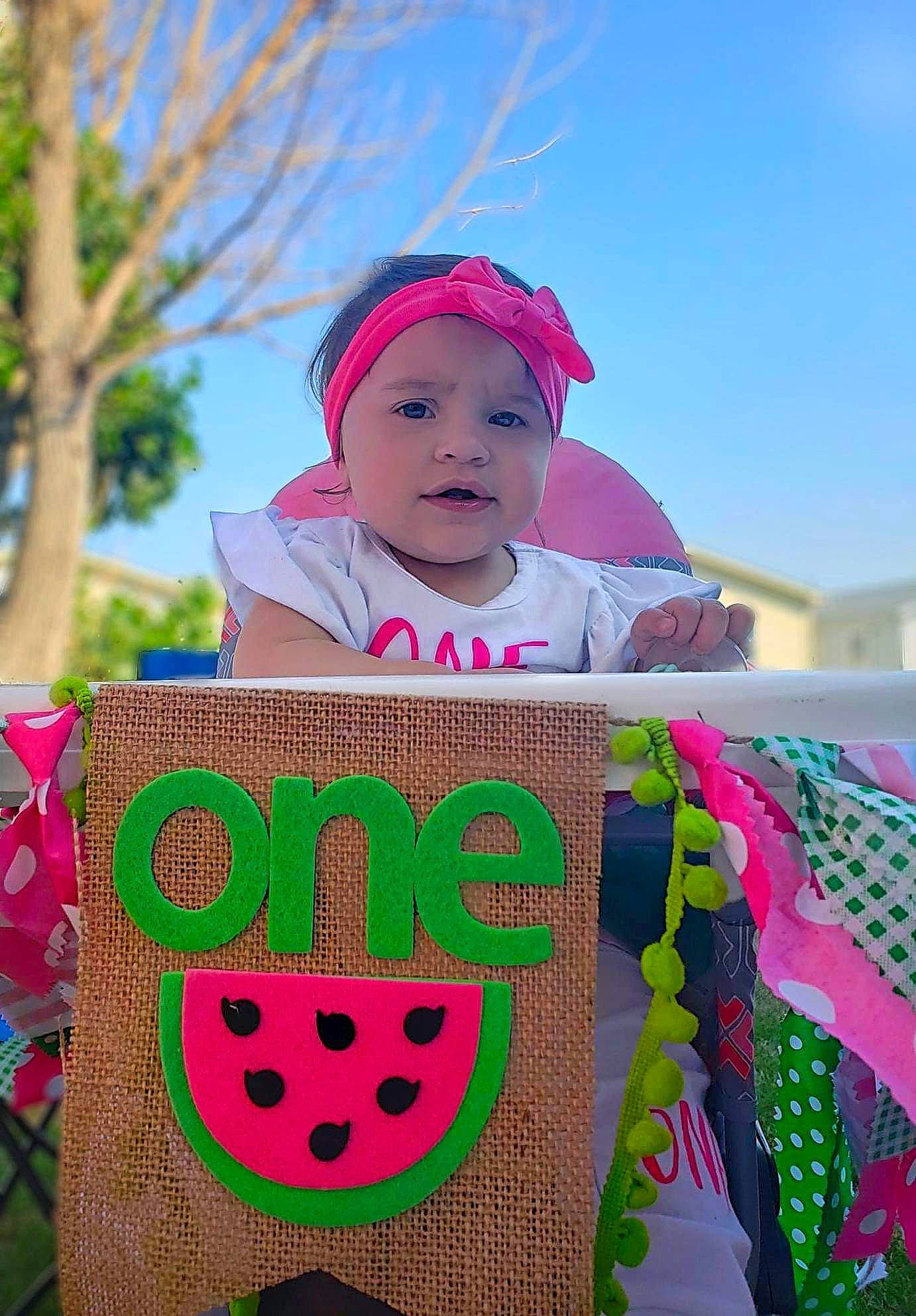 Tinsley is registered to the contest to win money with this photo: baby, baby_toddler_clothing, cap, event, facial_expression, fun, grass, green, happy, hat, headwear, leaf, magenta, person, pink, plant, red, sky, summer, sun_hat
