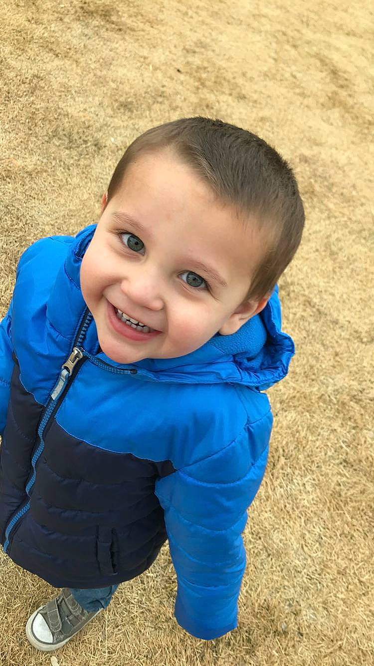 Caesar is registered to the contest to win money with this photo: baby, blue, cheek, child, electric_blue, eye, face, forehead, grass, hair, hairstyle, head, joy, lip, male, nose, outerwear, person, skin, smile