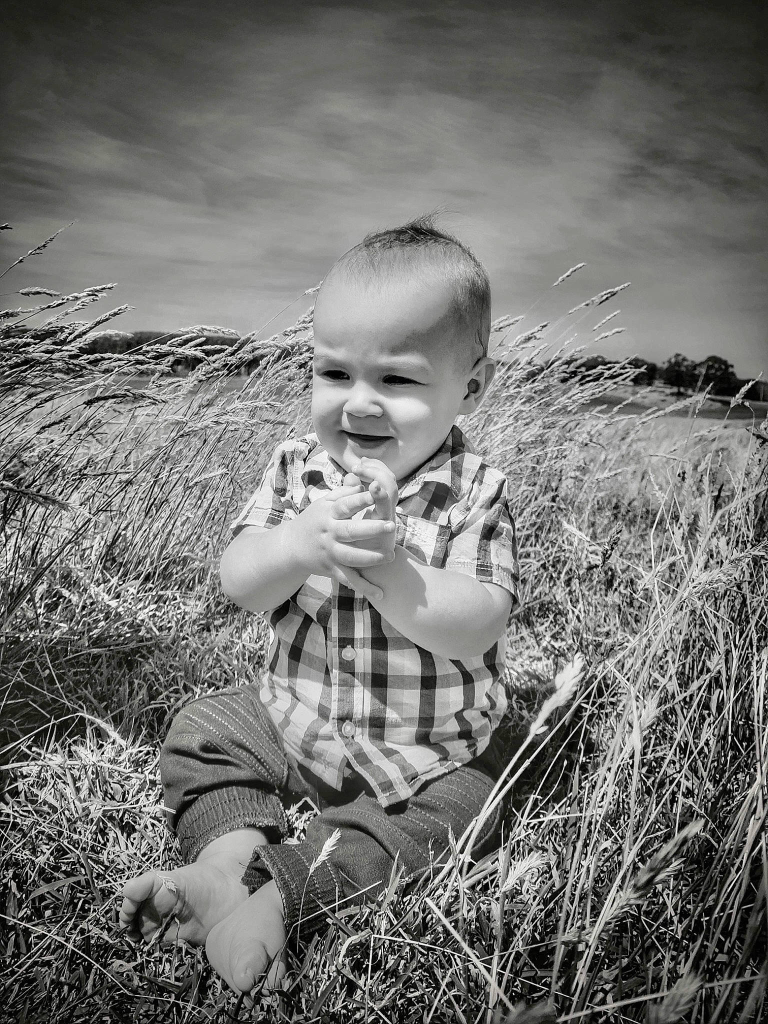 Colton is registered to the contest to win money with this photo: baby, black_and_white, cloud, field, flash_photography, grass, grassland, happy, landscape, meadow, monochrome, monochrome_photography, people_in_nature, person, plant, prairie, rural_area, sitting, sky, style