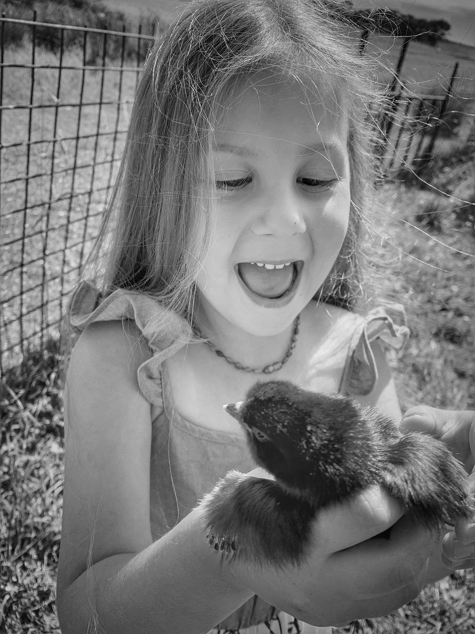 Starla is registered to the contest to win money with this photo: black_and_white, blond, fence, flash_photography, fun, gesture, grass, hand, happy, iris, long_hair, mesh, monochrome, monochrome_photography, people_in_nature, person, plant, smile, style, toddler
