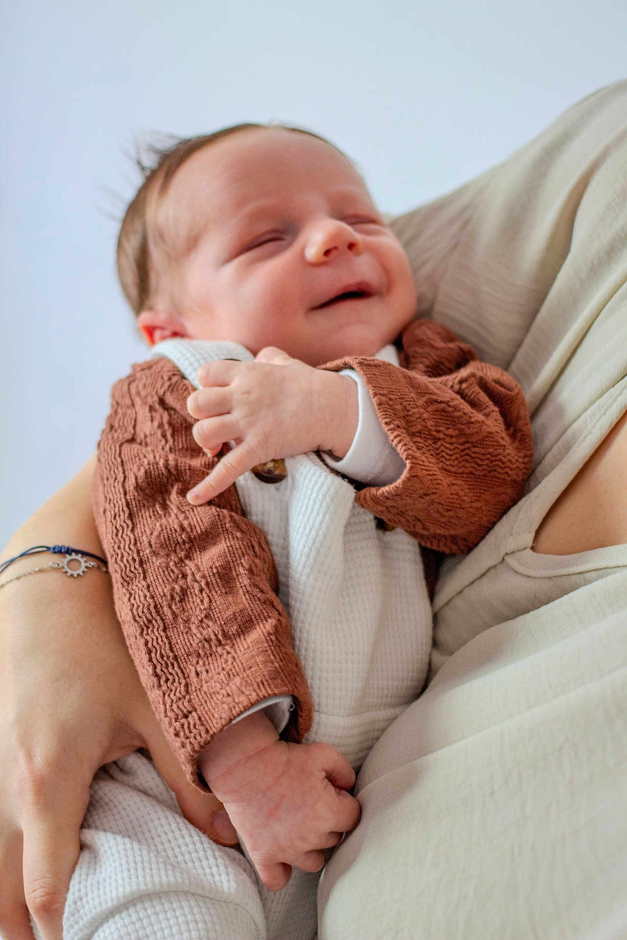 Léo participe au concours pour gagner de l'argent avec cette photo : baby, newborn, smile, sleepy, person, hand, arm, clothing, knitwear, white, brown, portrait, cute, infant, human, skin, soft, peaceful, toddler, holding