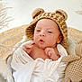 newborn, baby, infant, knitted_hat, bear_ears, blanket, crocheted_toy, teddy_bear, pampas_grass, soft_texture, cozy, wrapped, cute, portrait, indoor, white_blanket, baby_hands, headwear, decor, closeup