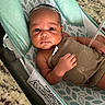 Ryden is registered to the contest to win money with this photo: newborn, baby, infant, child, face, eyes, portrait, lying_down, baby_rocker, blanket, wrapped, indoors, kitchen, countertop, granite, mint_green, brown_blanket, safety_label, awake, photography