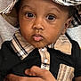 baby, bucket_hat, child, clothing, collar, curious, cute, eyes, face, hand, hat, holding, indoor, person, plaid, portrait, shirt, skin, tattoo, toddler